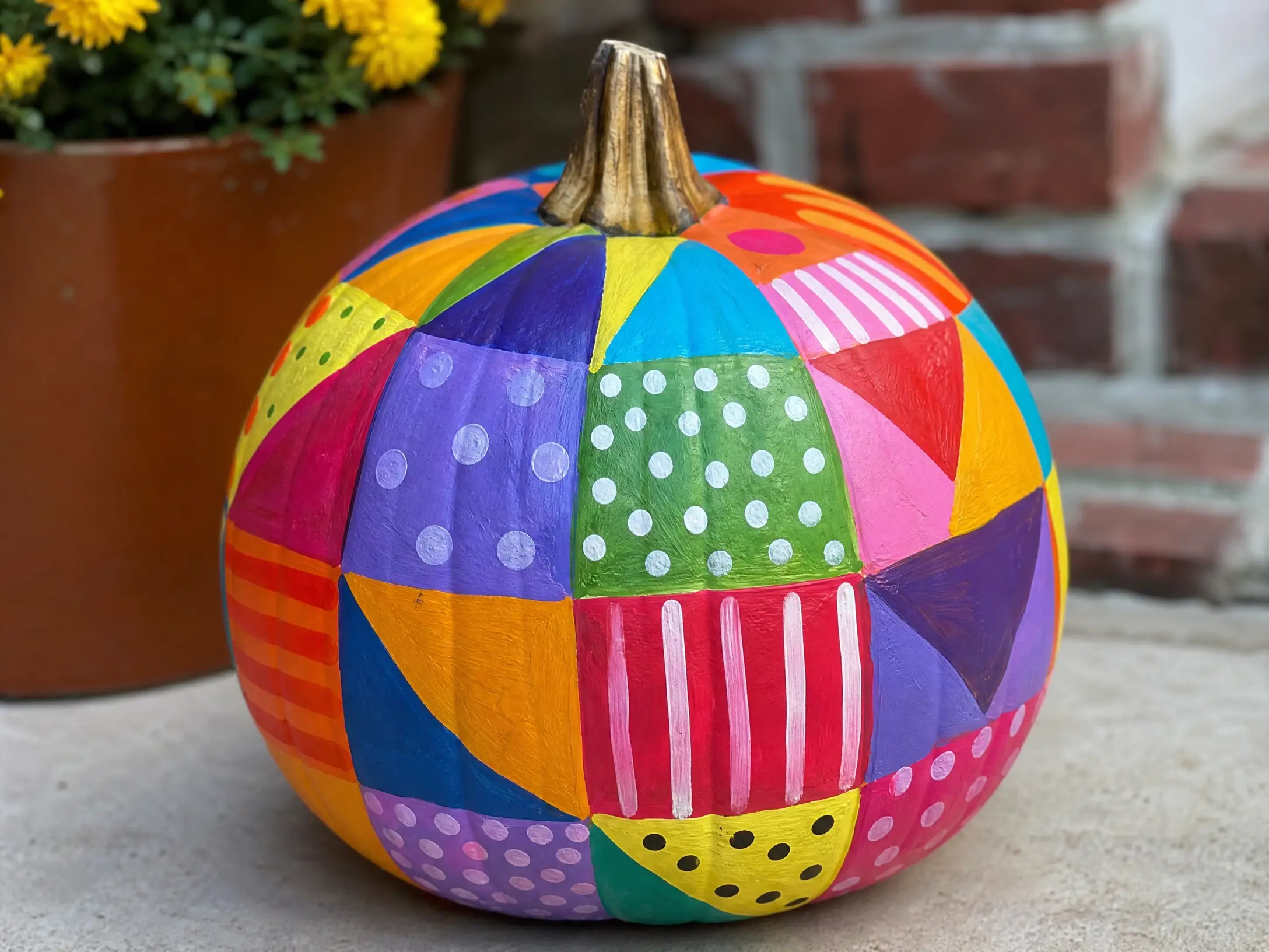 Orange pumpkin painted in a bright rainbow patchwork pattern