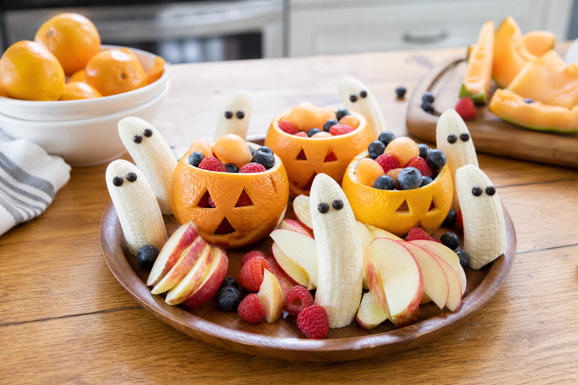 Banana ghosts and pumpkin fruit cups made as wholesome Halloween snacks