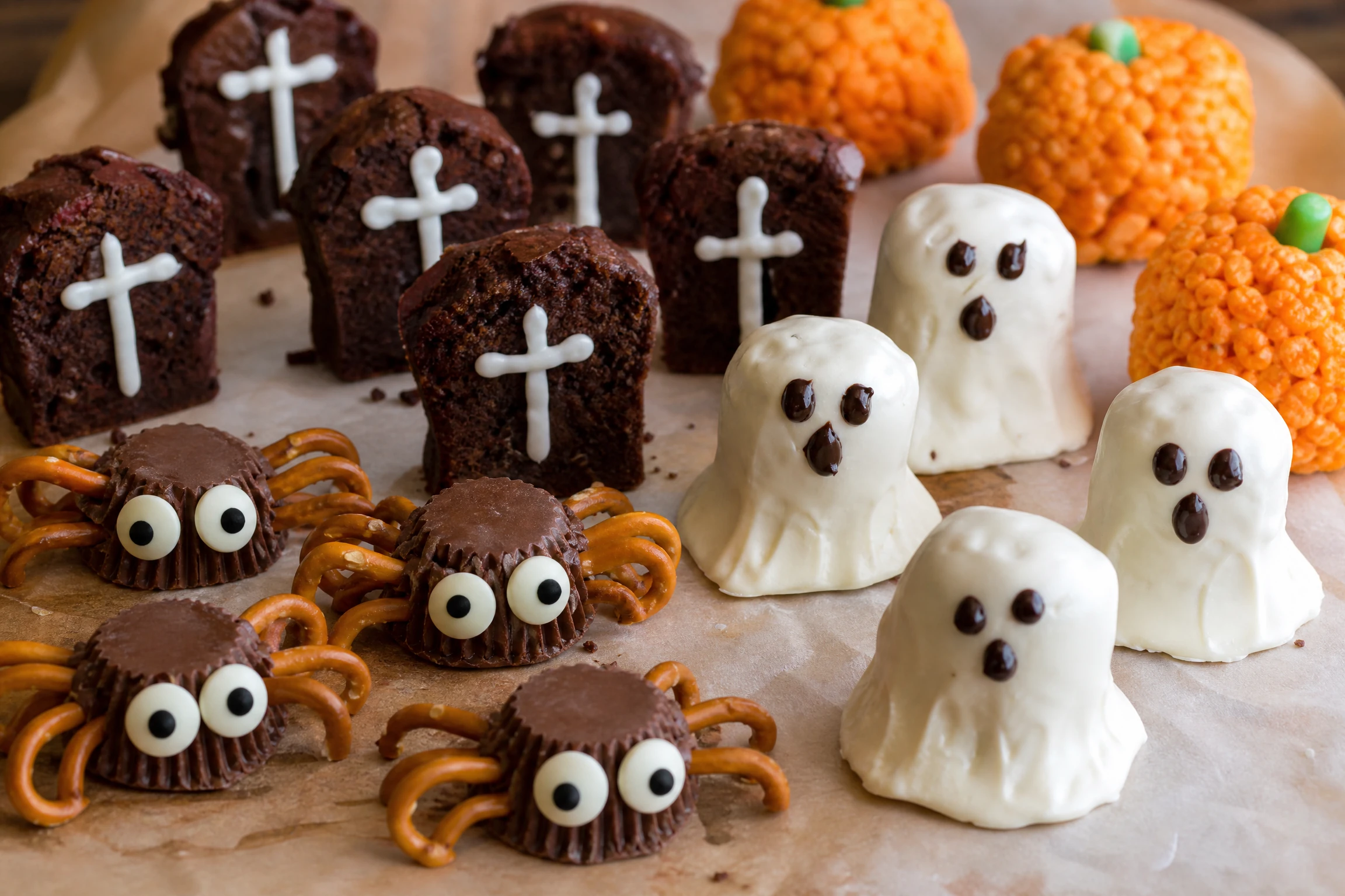 Marshmallow ghosts and Halloween desserts arranged on a party table